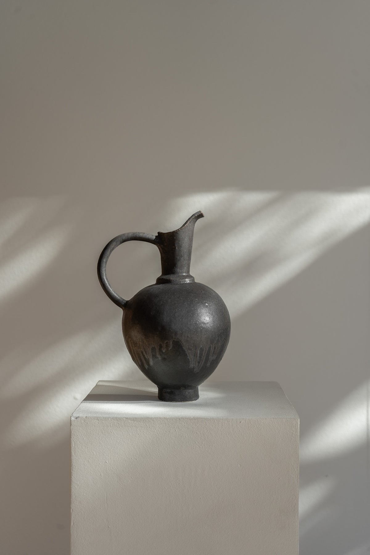 Handmade Oinochoe Pitcher INK by Canoa Lab, featuring a matte black glaze and textured stoneware. Inspired by ancient Mediterranean design, this decorative vase adds timeless elegance to any space.