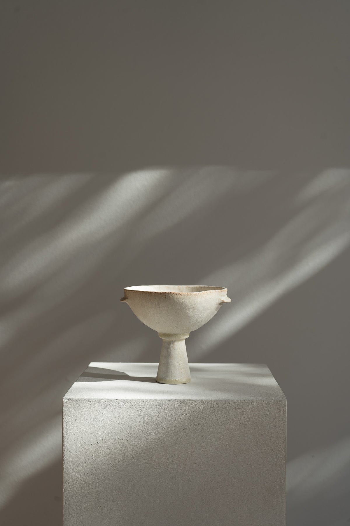 The bowl features a matte cream glaze with a textured surface that evokes ancient Mediterranean artifacts. Its design reflects the fusion of modern and ancient influences, with slight variations that add character to each unique piece.