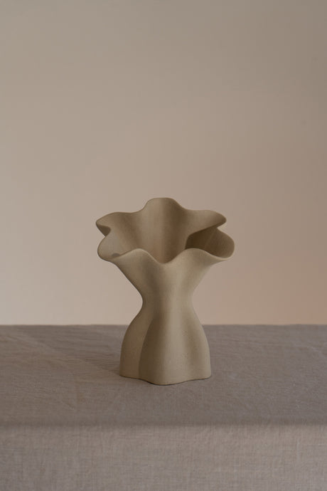 A beautifully crafted matte taupe ceramic vase with soft, organic shapes and a glazed interior. 