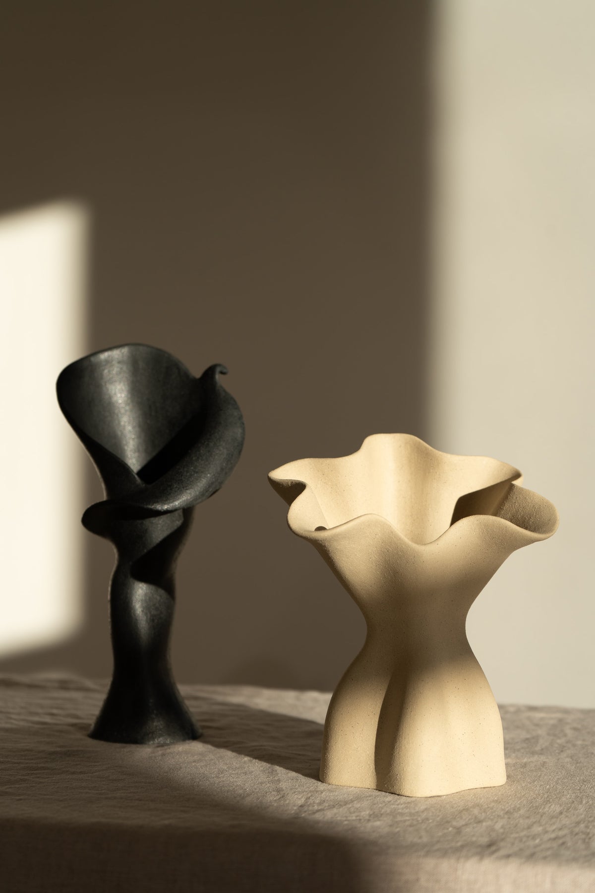  A matte black ceramic vase inspired by the Calla Lily, blending floral curves with bold stoneware. Features a glazed interior, perfect as a striking modern decor piece.