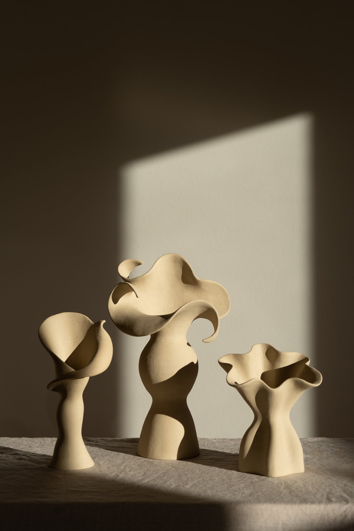 A matte taupe ceramic vase inspired by the Calla Lily, combining bold stoneware with soft floral curves. 